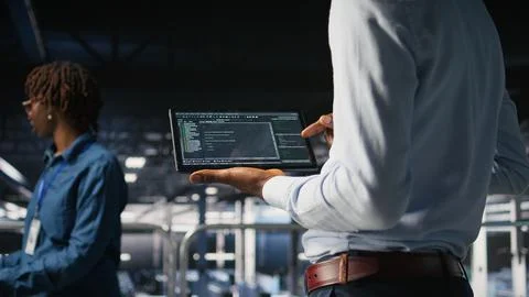 Close up of programmer swiping on tablet display in data center, checking code 库存照片