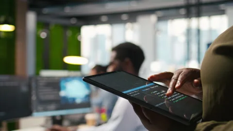 Close up of programmer utilizing AI on tablet to optimize performance Stock-Footage 313014532