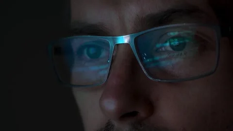 Close-up of a programmer wearing glasses, with programming code reflected Video stock 297309742