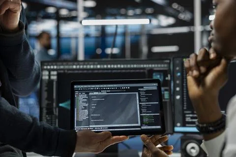 Close up of programmers coding on tablet in data center, refining algorithms Stock-Fotos