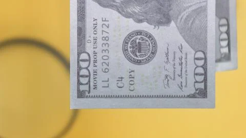 Close-up of a prop US dollar bill against a yellow background, perfect for .. Stock Photos