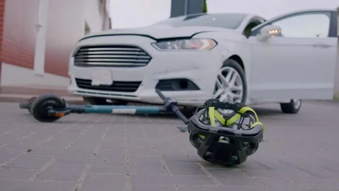 Close-up of a protective head helmet spinning down on the asphalt after a Stock Footage 246605956