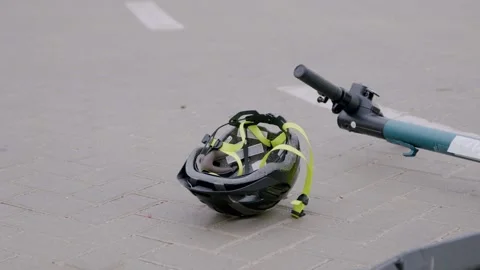 Close-up of a protective head helmet spinning down on the asphalt after a Stock Footage 247173289