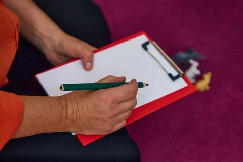 Close-up of psychologist taking notes during child session Stock Photos