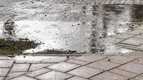 Close up of puddle of rain with rain falling Stock Footage 283046084