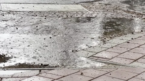Close up of puddle of rain with rain falling Stock Footage 302508934