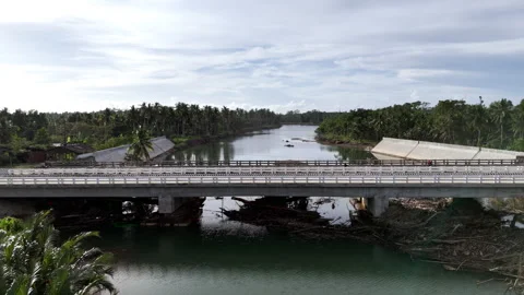 Close-up pullaway drone shot of Babuyan Bridge showing accumulated storm debris Stock Footage 332226550