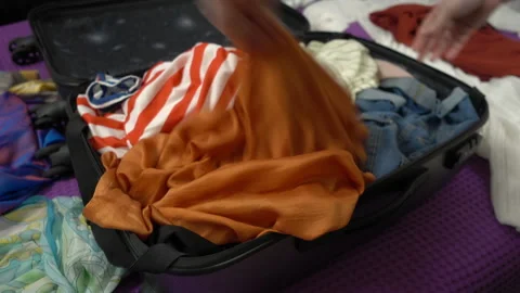 Close up of pulling clothes out of a suitcase and scattering clothes around. Stock Footage 105624949