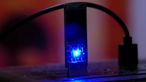 A close-up pulling a flashing, flash drive out of a computer's USB port. Video stock 346881998