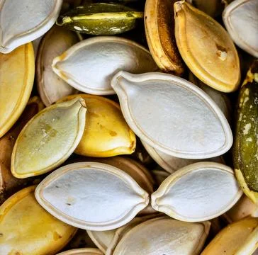 Close up pumpkin seeds surface showing organic plant based food texture Stock Photos