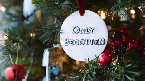 Close push on "Only Begotten" circular ornament on Christmas tree 8K Stock Footage 123479600