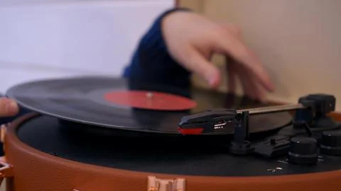 Close-up put a vinyl record in the turntable and lower the needle to listen to Stock Photos