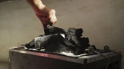 Close-up putting and arranging pieces of coal in a chinese box with the fingers Stock Footage 170020175