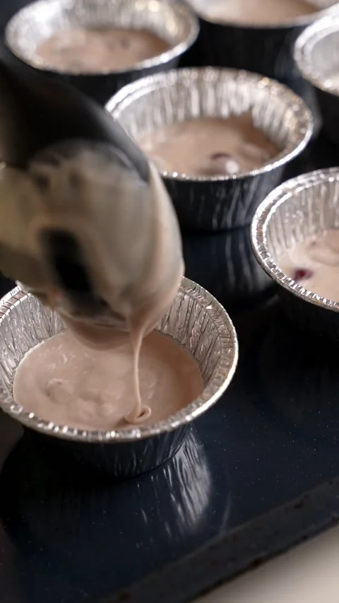 Close up of putting dough with berries into Cupcake Baking Muffin Cup Stock Footage 236396558