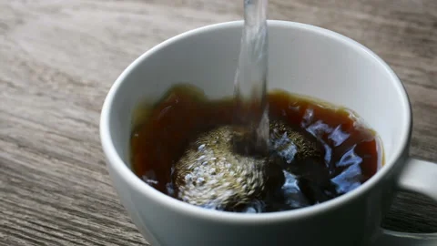 Close up of Putting instant coffee in a cup on wooden table and Pour hot water Stock Footage 132206254