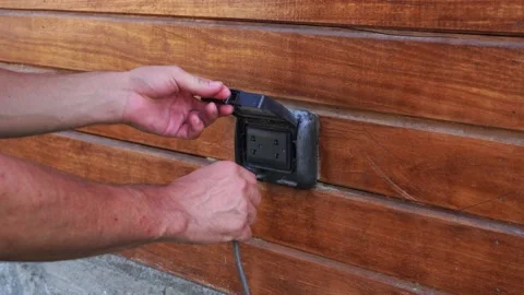 Close-up putting an outdoor plug with a door to cover it from the rain with the Stock Footage 199511212
