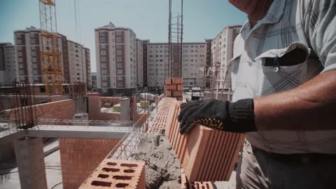Close up of putting a red brick on his place in the wall Stock Footage 143787378