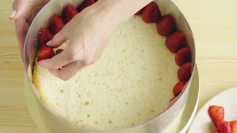Close-up of putting strawberries on a sponge cake Stock Footage
