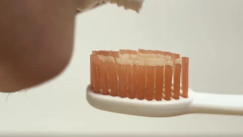 Close-up putting toothpaste on a toothbrush Stock Footage 253440168