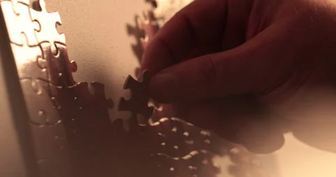 Close-up of the puzzle. A hand that puts a part of the puzzle. Stock Footage 240136574