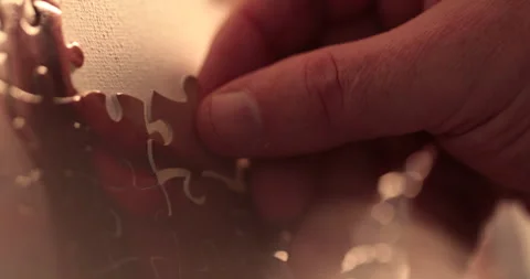 Close-up of the puzzle. A hand that puts a part of the puzzle. Stock Footage 240136812