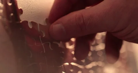 Close-up of the puzzle. A hand that puts a part of the puzzle. Stock Footage 240136902