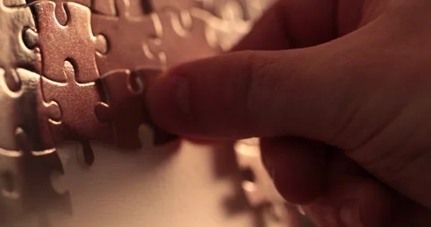 Close-up of the puzzle. A hand that puts a part of the puzzle. Stock Footage 240137011