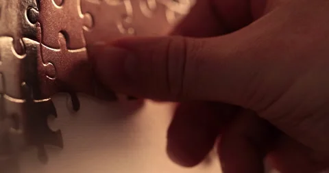 Close-up of the puzzle. A hand that puts a part of the puzzle. Stock Footage 240137334