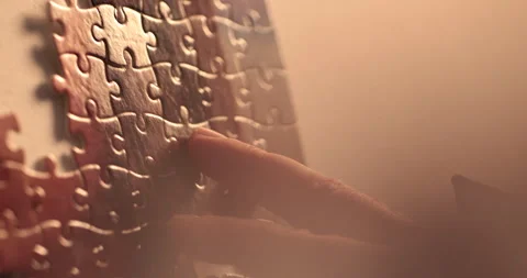 Close-up of the puzzle. A hand that puts a part of the puzzle. Stock Footage 240137566