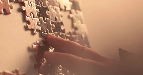 Close-up of the puzzle. A hand that puts a part of the puzzle. Stock Footage 240137673