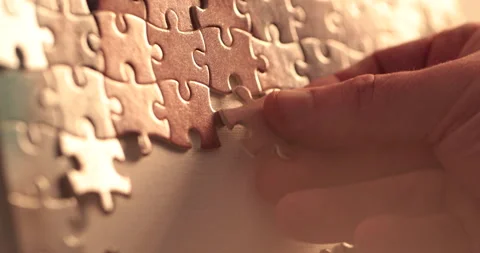 Close-up of the puzzle. A hand that puts a part of the puzzle. Stock Footage 240137878