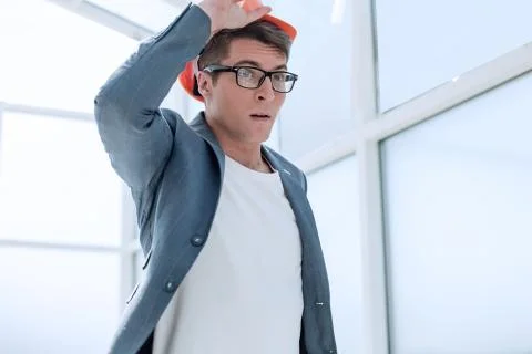 Close up. puzzled young architect adjusted his helmet Stock Photos