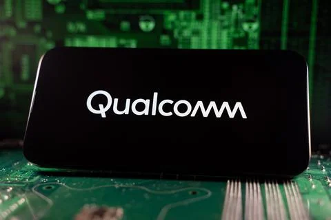 Close up of Qualcomm logo on smartphone screen with motherboard background. Stock Photos