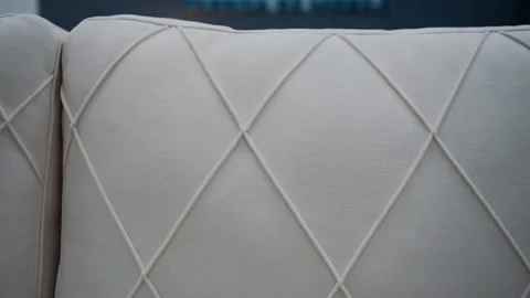 Close-up to the quality of the white sofa with rhombus-shaped lines. 4k video. Video stock 235056828