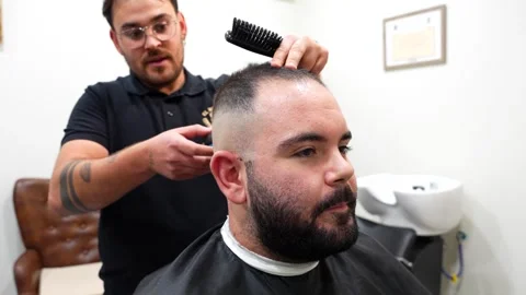 Close up of quiet client while hairdresser talks during cut Stock Footage 320394448