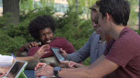 Close-up of racially-diverse students laughing over a digital tablet Stock Footage 44117333