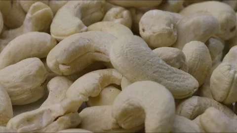 Close up rack focus of portion of raw cashew nuts on table. Zoom in Stock Footage 280260981