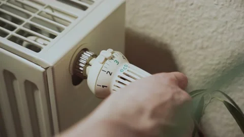 Close-up of a radiator, a hand is turning it up on the highest level Stock Footage 236010408
