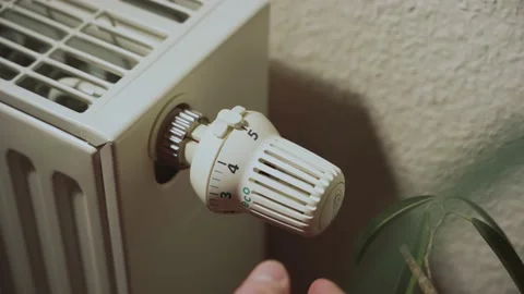 Close-up of a radiator, a hand is turning it down to the eco level Stock Footage 236010532