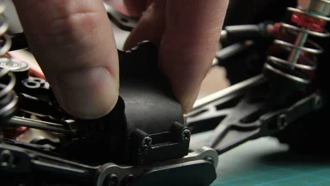 Close-up radio control model buggy car. The hands of the master disassemble the Vídeos de archivo 147404948