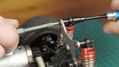 Close-up radio control model buggy car. The hands of the master disassemble the Vídeos de archivo 147405409
