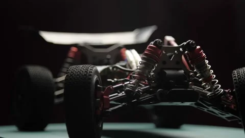 Close-up radio control model buggy car without shell rotating on cutting mat Vídeos de archivo 148045575