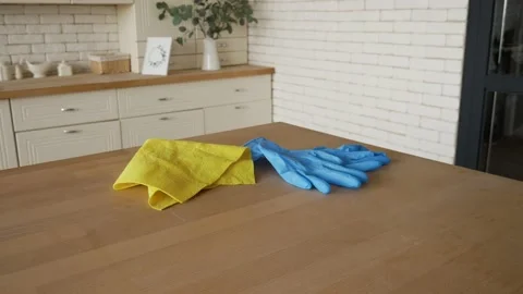 Close up of a rag and a pair of rubber gloves laying on the kitchen table Video stock 130845495