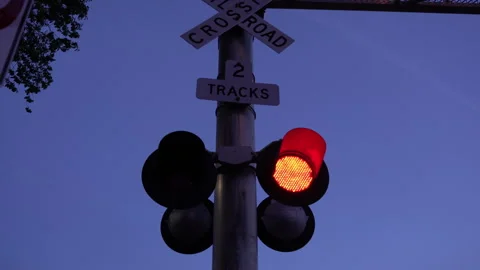 Close Up of a railroad train crossing gate at dusk Stock Footage 243543956