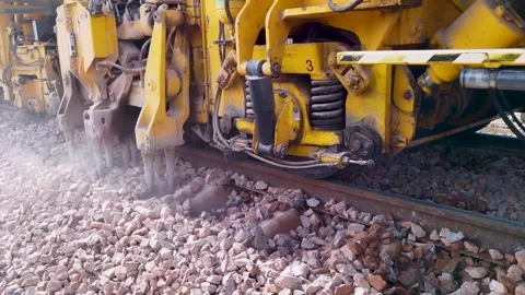 Close-up of a railway tamping machine working on track maintenance Stock Footage 328260317