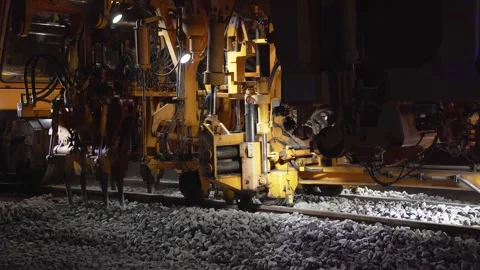 Close-up of a railway tamping machine working on track maintenance Stock Footage 328989910