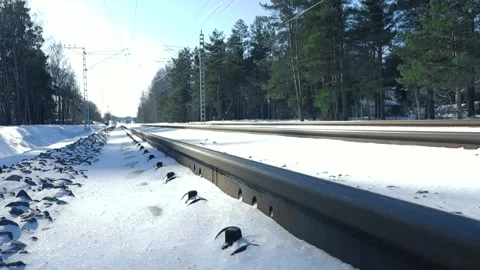Close up of railway tracks surrounded by white snow glistening under a sun Stock Footage 309277130