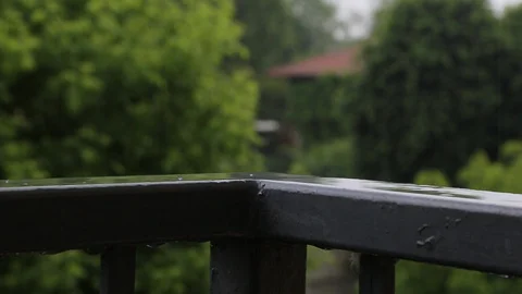 Close up of the rain bouncing on the corner of the balcony railing Stock Footage 130121771