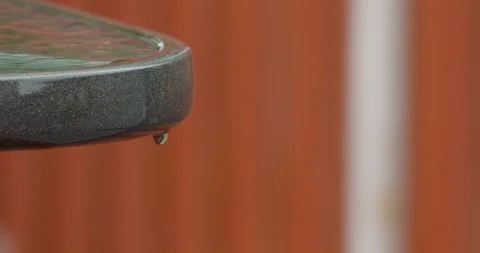 Close up rain drop from a back yard table Stock Footage 131923596