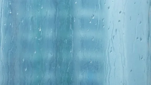 Close-up of rain droplets falling on window. Rainy day. Stock Footage 157384974